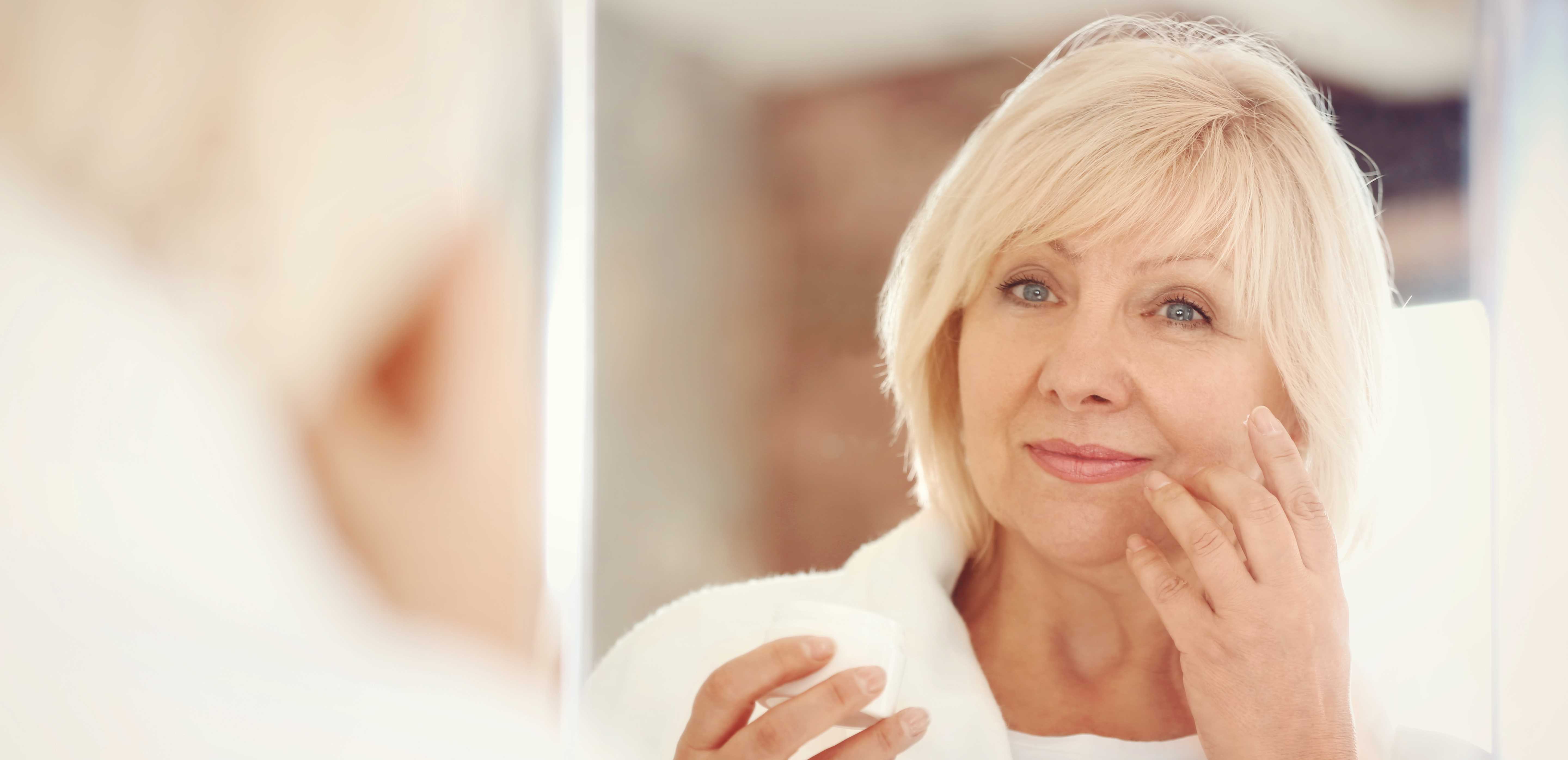 Our Fall 2019 Special on Skin Rejuvenation in Springfield Missouri -stock image of woman looking in a mirror